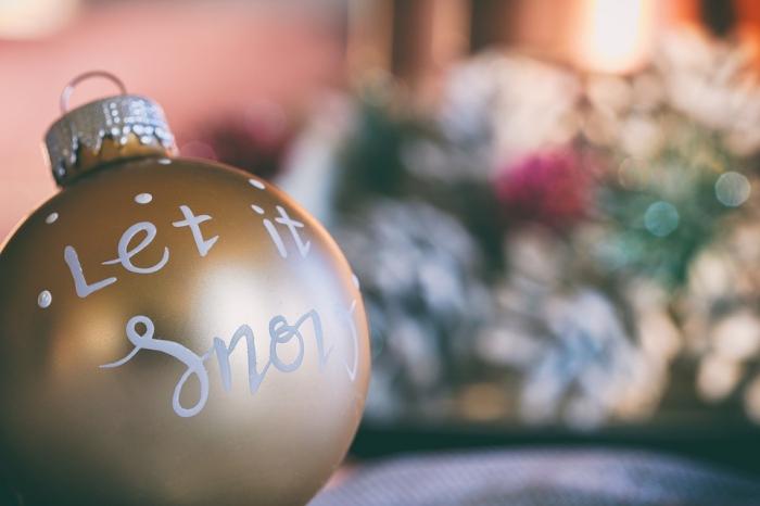 exemple de boule de noel transparente customisée avec peinture métallisée en or et dessins blancs à motifs Noël 