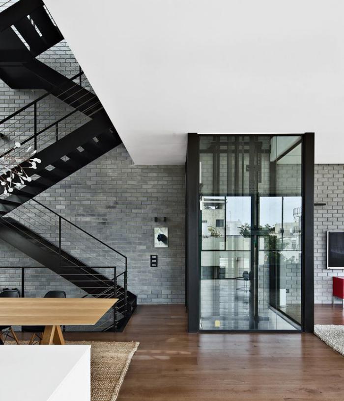 escalier-suspendu-métallique-mur-en-briques-grises