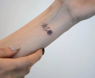 initiale en tatouage lettre fleur miniscule poignet femme manucure