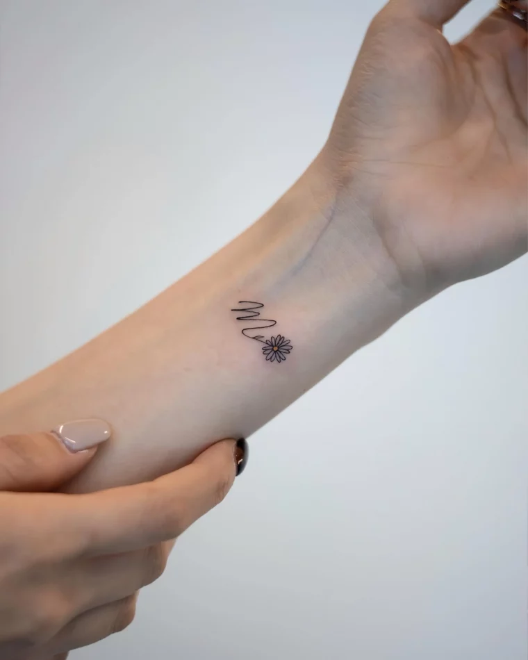 initiale en tatouage lettre fleur miniscule poignet femme manucure