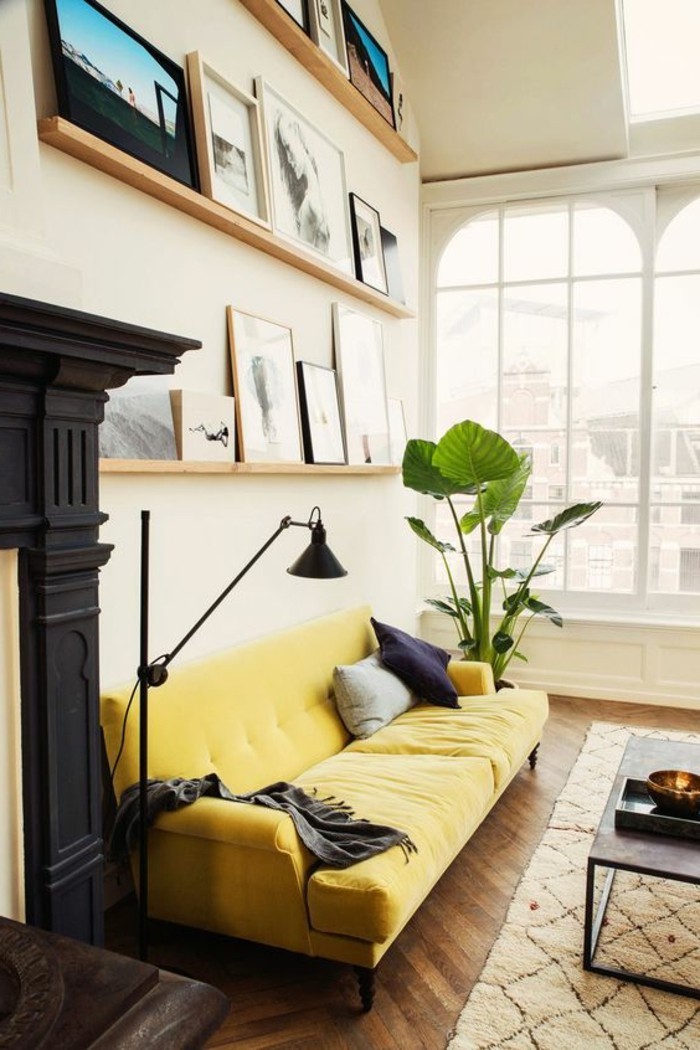 grande-canape-de-salon-jaune-tapis-beige-parquet-en-bois-foncé-plantes-vertes-d-interieur
