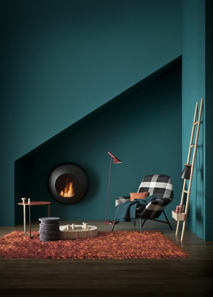 salon-avec-murs-de-couleur-bleu-foncé-tapis-orange-sol-en-parquet-foncé-lampe-de-lecture-rouge