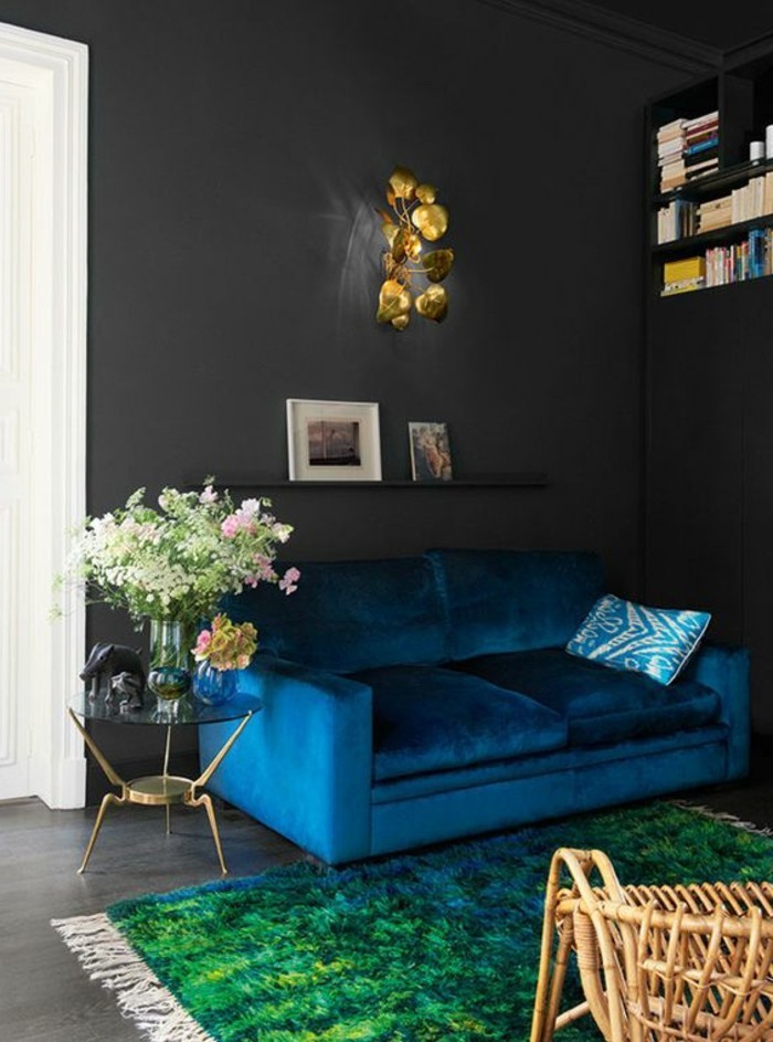 salon-chic-tapis-vert-canapé-bleu-foncé-chaise-en-rotin-bois-clair-meubles-de-salon