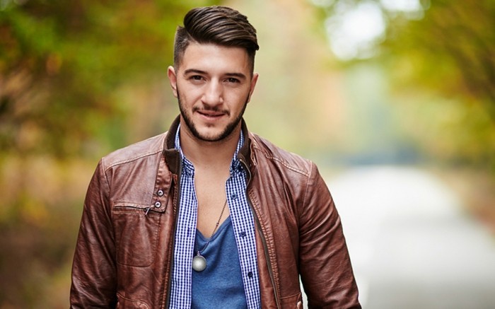 Fashionable young man in leather jacket outdoor in a forest