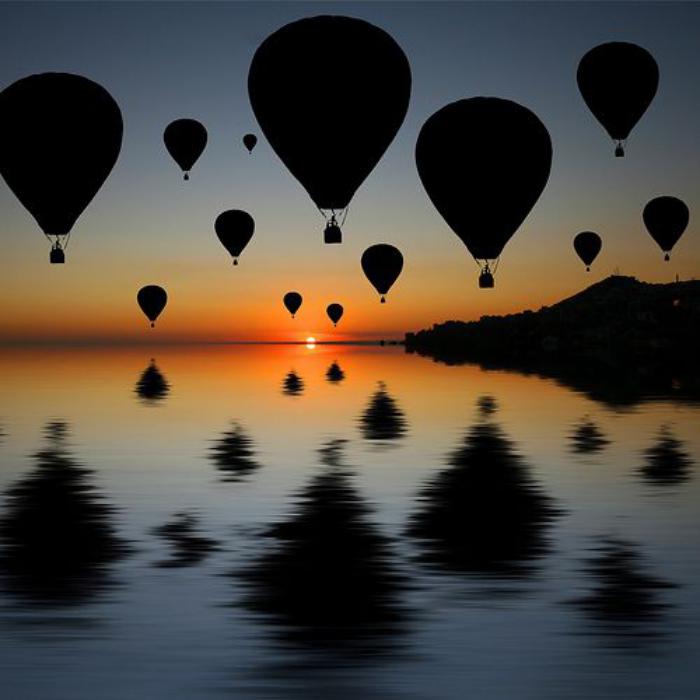 vol-en-montgolfière-multitude-de-ballons-volants-au-coucher-du-soleil