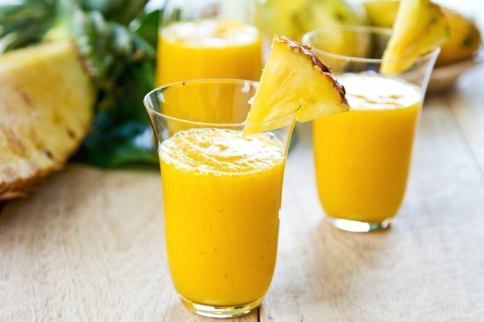 Mango with pineapple smoothie in jug and glasses