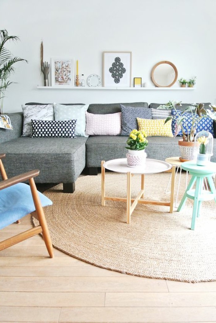 tapis-en-rotin-beige-meubles-en-bois-clair-canape-gris-avec-coussins-colorés-murs-blancs
