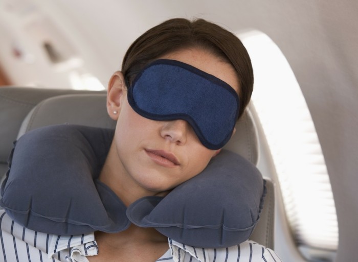 A businesswoman asleep on a flight