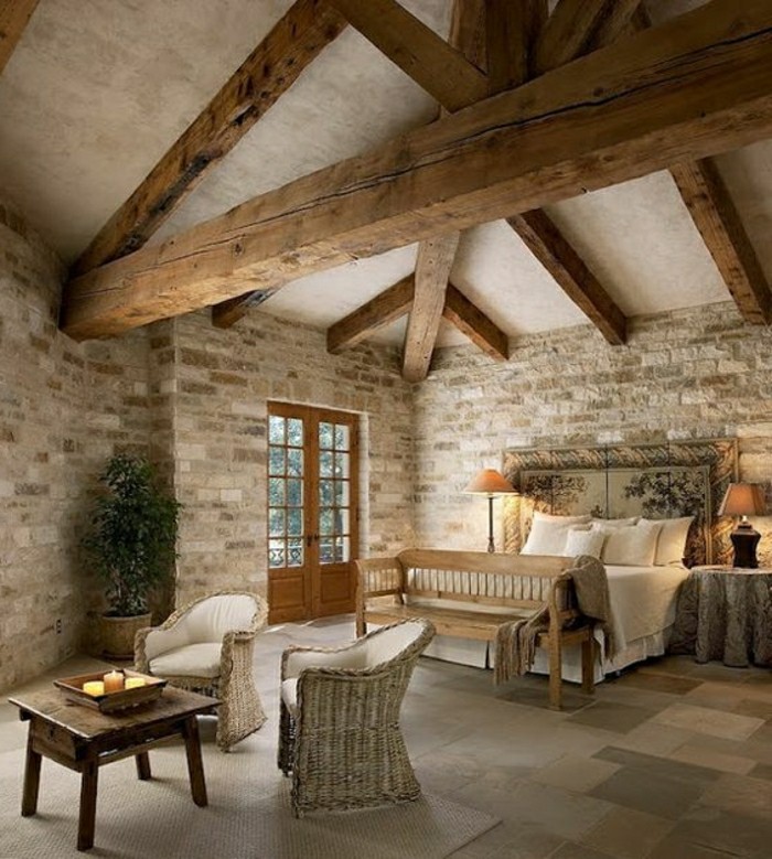 salon-dans-la-chalet-interieur-en-pierre-sol-en-carreaux-beiges-plafond-sous-combles-resized