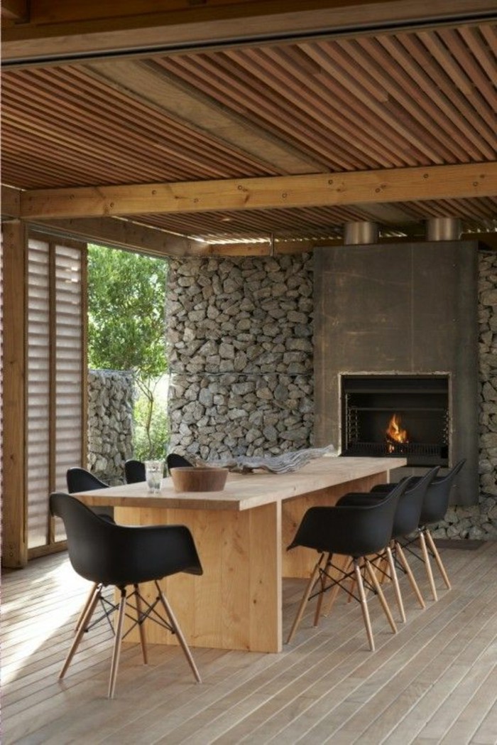 sol-en-planchers-clairs-meubles-de-cuisine-table-en-bois-clair-mur-en-pierres-chaise-noire
