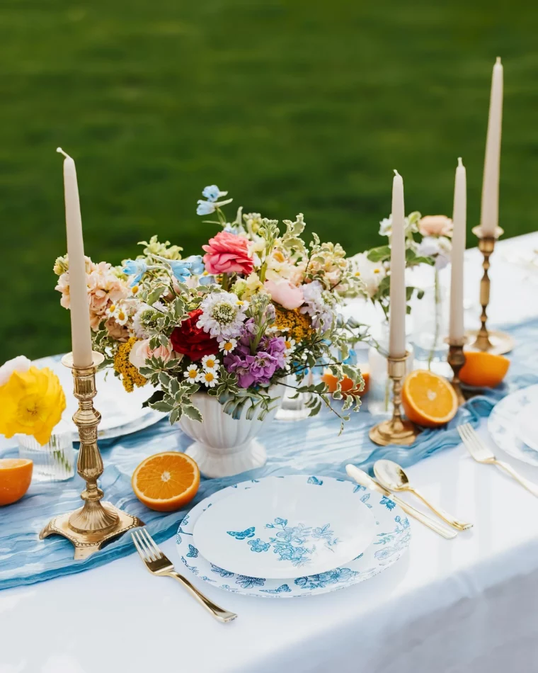 chemin de table bleu moitie agrumes bougeoirs vase bouquets colores fleurs