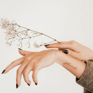 mains femme ongles vernis noir gel branche sechee fleurs