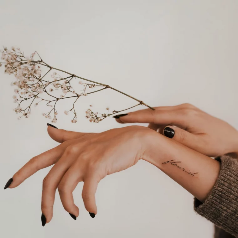 mains femme ongles vernis noir gel branche sechee fleurs