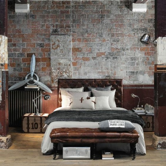 chambre-a-coucher-tete-de-lit-capitonnée-simili-cuir-marron-sol-en-parquet-clair-mur-en-briques