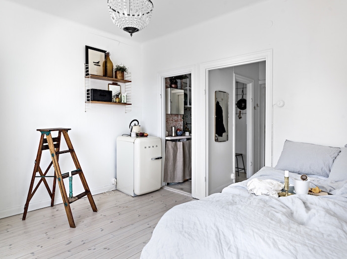 murs blancs дdans une chambre à coucher gris et blanc semi ouverte sur cuisine, deco murale etagere bois et metal, amenagement petit espace