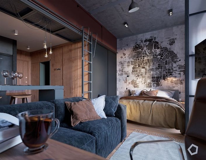 cuisine bois et gris ouverte sur salon avec canapé gris anthracite, chambre avec lit et tete de lit papier peint original, decoration loft industriel