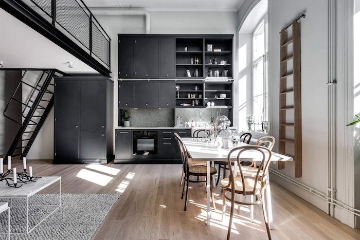 decoration cuisine noire ouverte sur salle à manger avec table blanche et chaises de bois, parquet bois clair, coin sejour style scandinave