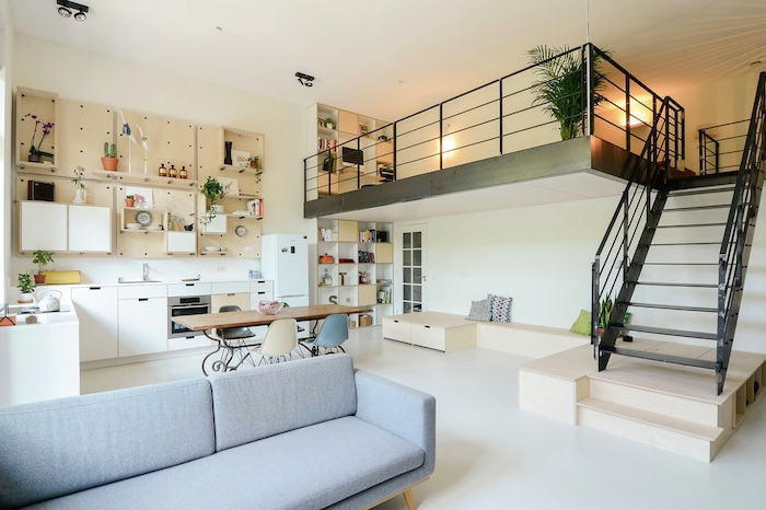idée amenagement petit appartement avec cuisine d angle blanche, rangement cuisine panneau perforé, sol blanc et canapé gris