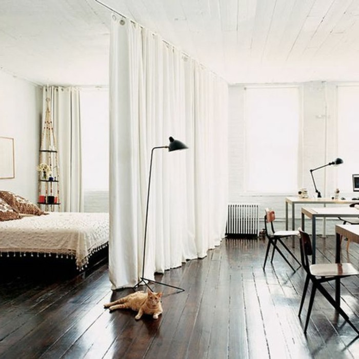 studio-rideau-séparation-chambre-rideau-blanc-sol-en-planchers-bois-foncé-murs-blancs