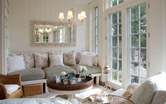 idée-déco-petit-salon-ambiance-romantique-grand-canapé-coussins-à-motifs-floraux-table-basse-fauteuil-en-rotin-grand-miroir-réflecteur