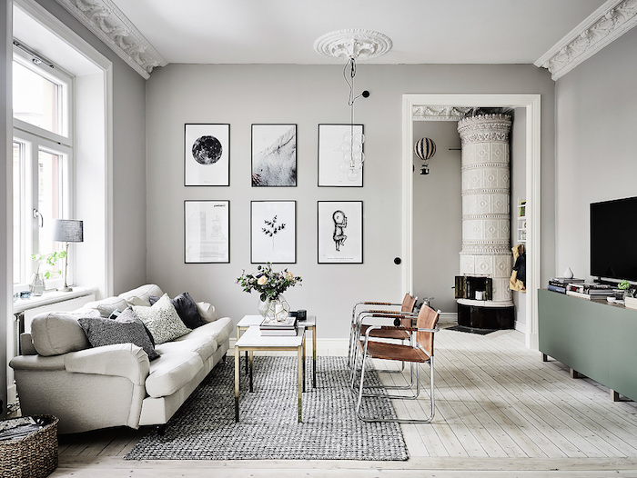 intérieur aux murs repeints de peinture grise, cheminée design, canapé blanc et chaises marron cuir, tapis gris, meuble tv vert de gris