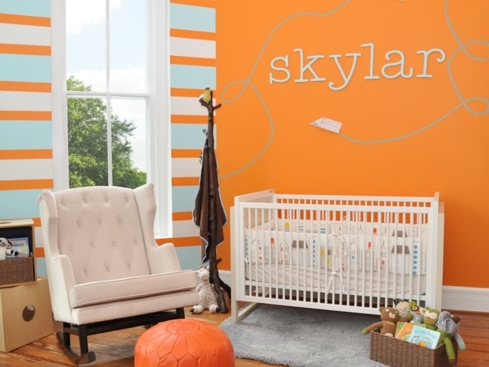 peinture-chambre-bébé-orange-qui-crée-une-ambiance-enjouée-lit-blanc-à-barreaux-poufe-orange-panier-de-rangement