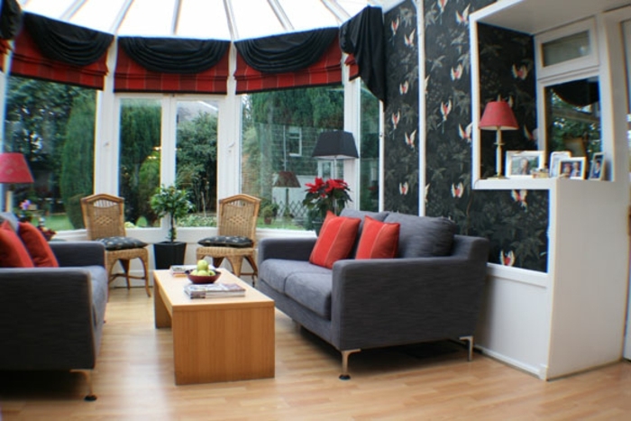 amenagement-veranda-en-noir-rouge-et-gris-chaises-en-rotin-table-basse-en-bois-veranda-de-luxe