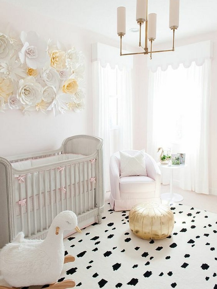 peinture-chambre-bébé-en-rose-clair-cheval-à-bascule-lit-bébé-petit-canapé-tapis-à-taches-noires-très-jolie-déco-murale-en-fleurs