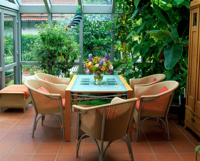 amenagement-veranda-en-salle-à-manger-meubles-en-rotin-table-en-verre-et-bois-veranda-florale