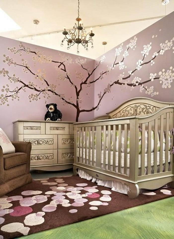 deco-chambre-bebe-fille-rose-avec-une-jolie-déco-murale-arbre-commode-et-lit-à-barreaux-couleur-or-fauteil-marron-tapis-marron