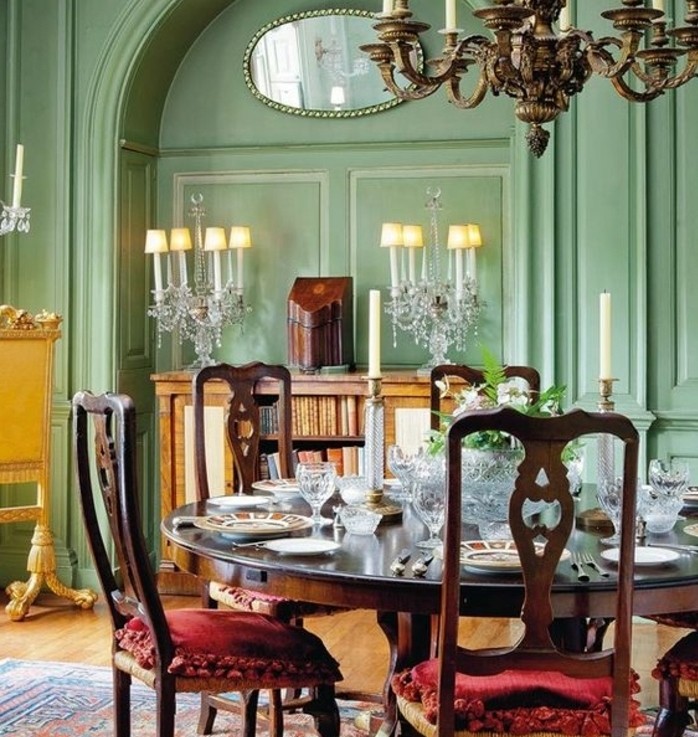 decoration-salle-à-manger-verte-ambiance-exquise-lustre-impressionnantes-table-en-bois-chaises-en-bois-à-sièges-rouges