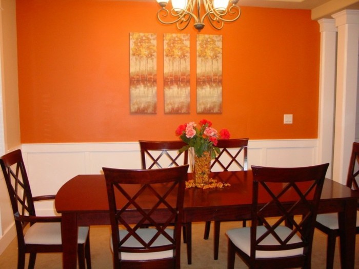 deco-salle-a-manger-orange-jolies-panneaux-décoratifs-accrochés-sur-le-mur-table-et-chaises-en-bois