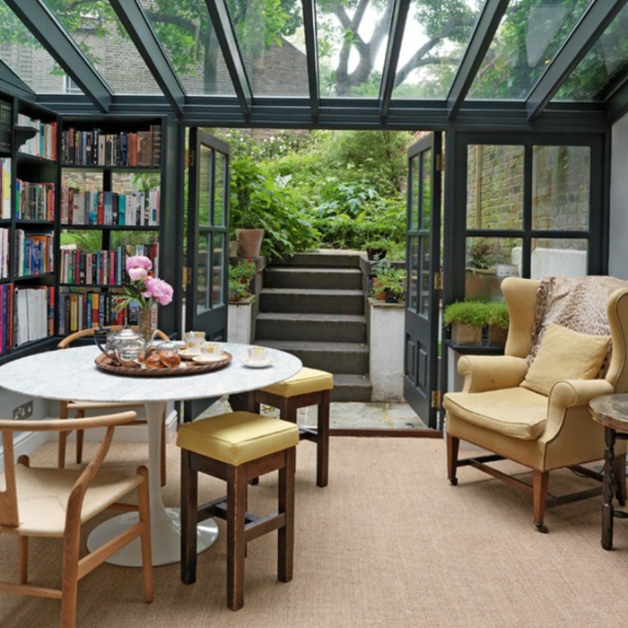 deco-veranda-aménagée-en-coin-détente-bibliothèque-table-et-chaises-en-bois-joli-fauteuil-vintage-le-meilleur-espace-pour-s-adonner-à-la-lecture