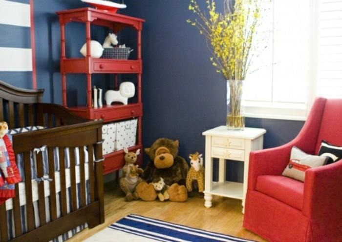 peinture-chambre-bébé-en-bleu-foncé-avec-des-accents-rouges-un-lit-à-barreaux-en-bois-une-étagère-rouge