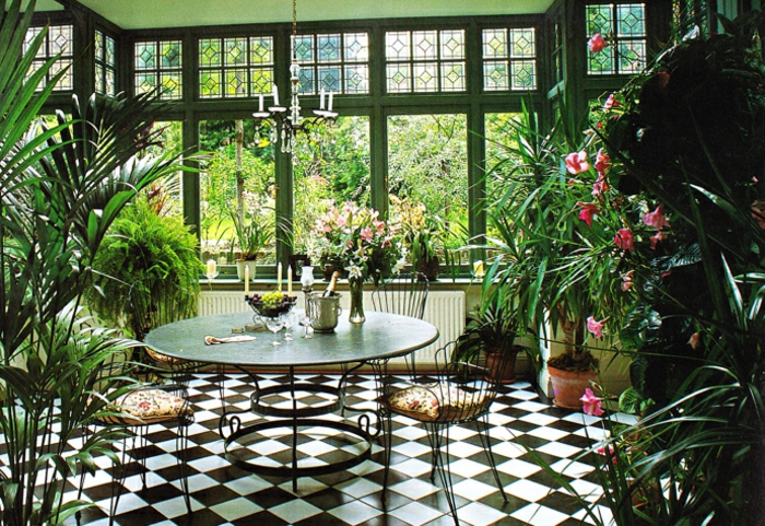 deco-veranda-aménagée-en-jardin-d-hiver-intérieur-veranda-plongée-dans-la-verdure-table-ronde-des-chaises