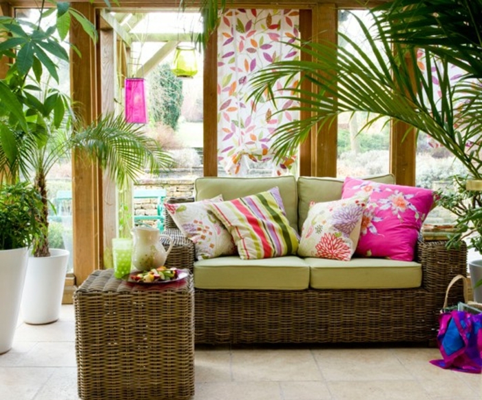 deco-veranda-dans-un-style-tropical-aménagée-avec-beaucoup-de-plantes-meubles-en-rotin-coussins-multicolores