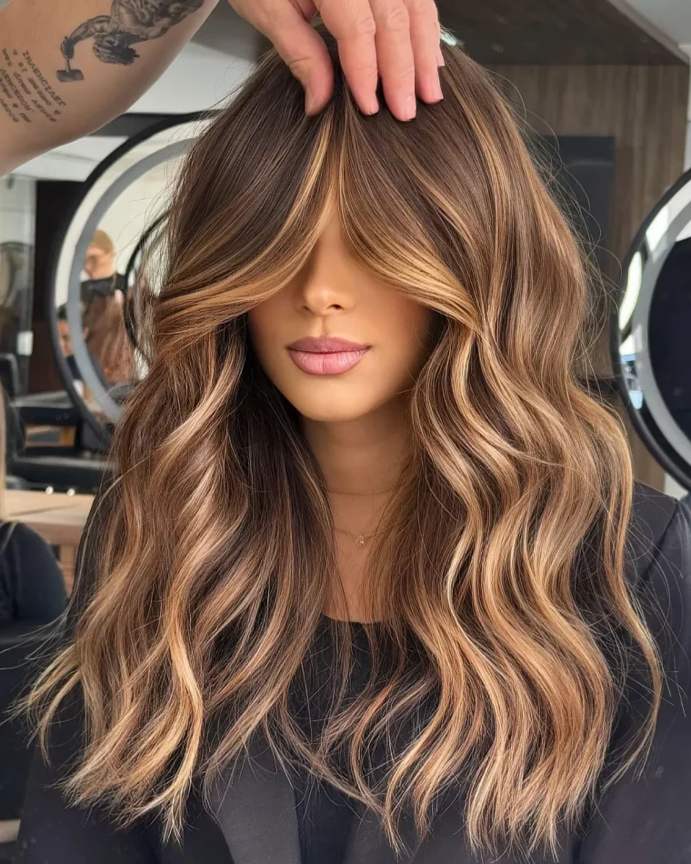 balayage caramel sur cheveux chatain ondules avec frange