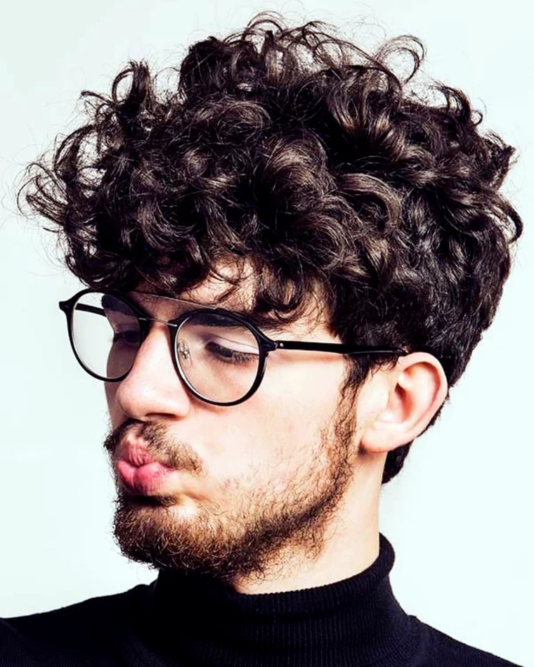 coiffure pour homme cheveux boucles avec des lunettes et barbe