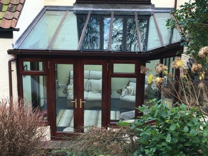 modele-de-veranda-en-aluminium-imitation-bois-veranda-toit-plat-plongé-dans-la-verdure