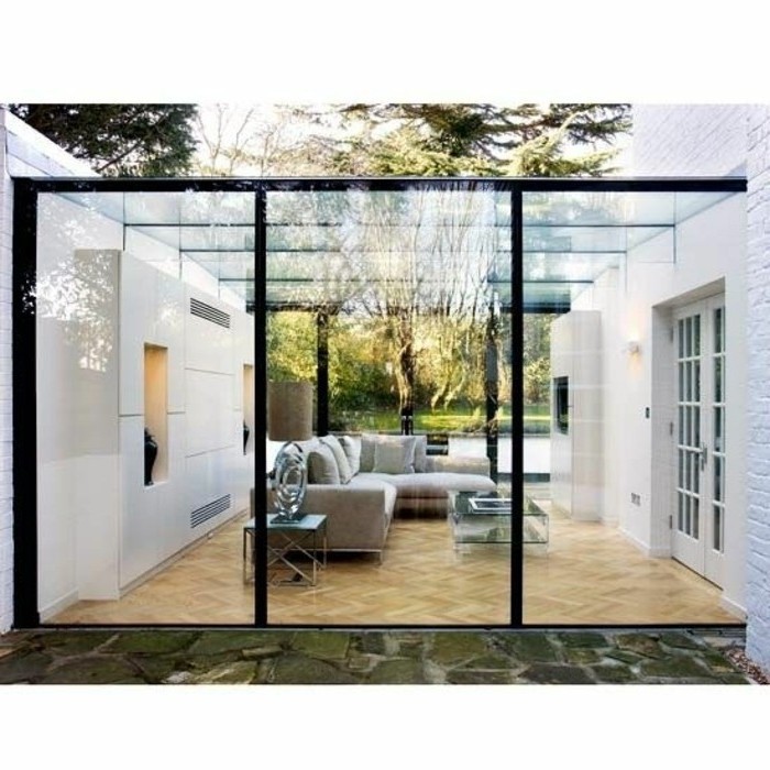 modele-de-veranda-en-verre-ultra-moderne-deco-veranda-contemporaine-canapés-gris-petite-table-basse-en-verre