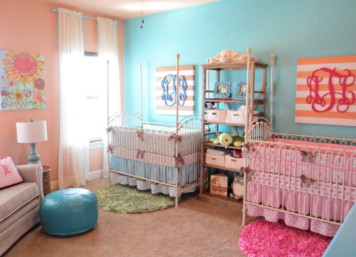 peinture-chambre-bebe-en-rose-et-bleu-pour-des-jumeaux-fille-et-garcon-deux-lits-à-barreaux-étagère-tapis-rose-et-tapis-vert-beaux-éléments-décoratifs