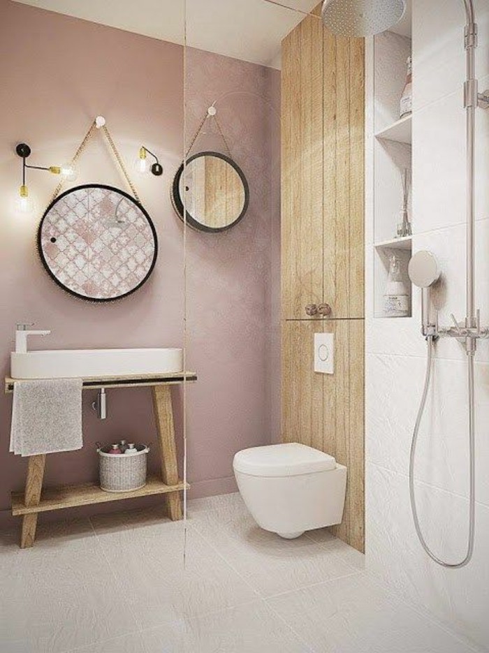 salle-de-bain-rose-pale-miroir-rond-sol-en-dalles-beiges-luminaire-design-mur-en-rose