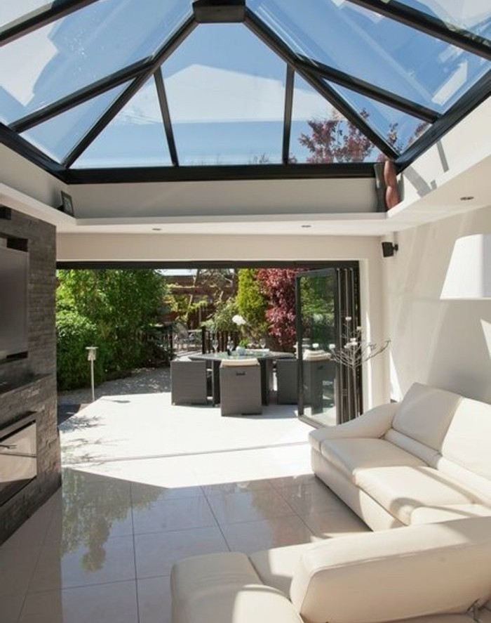 veranda-moderne-qui-donne-sur-un-jardin-toit-veranda-en-verre-canapé-blanc-un-coin-de-repos-magnifique