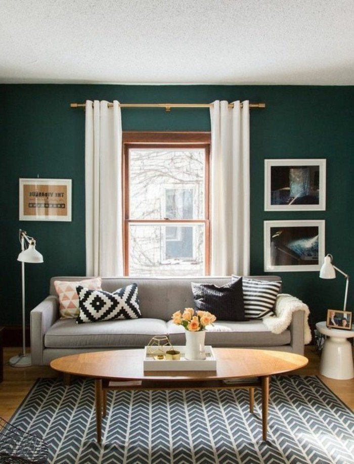 une-solution-tres-tendance-couleur-mur-salon-vert-émeraude-canape-gris-table-ovale-tres-sympa-tapis-en-noir-et-blanc