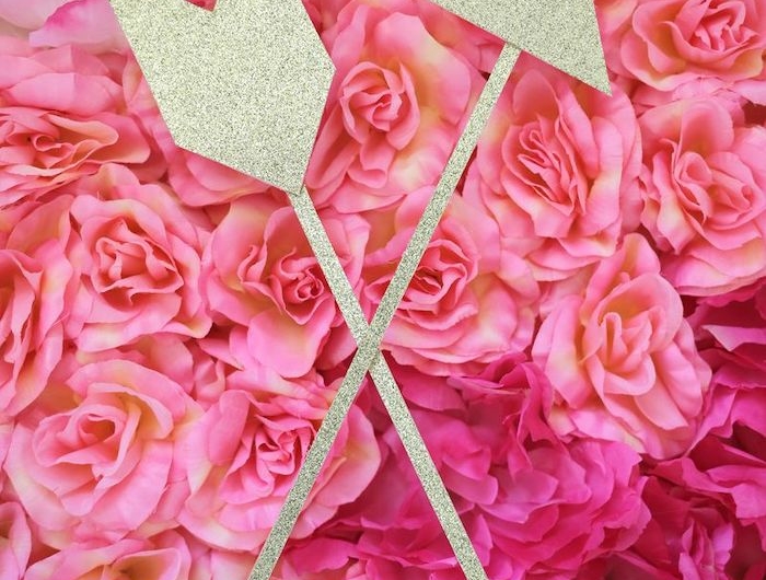 activité manuelle saint valentin deux flèches en bois et papier pailleté sur des roses fausses