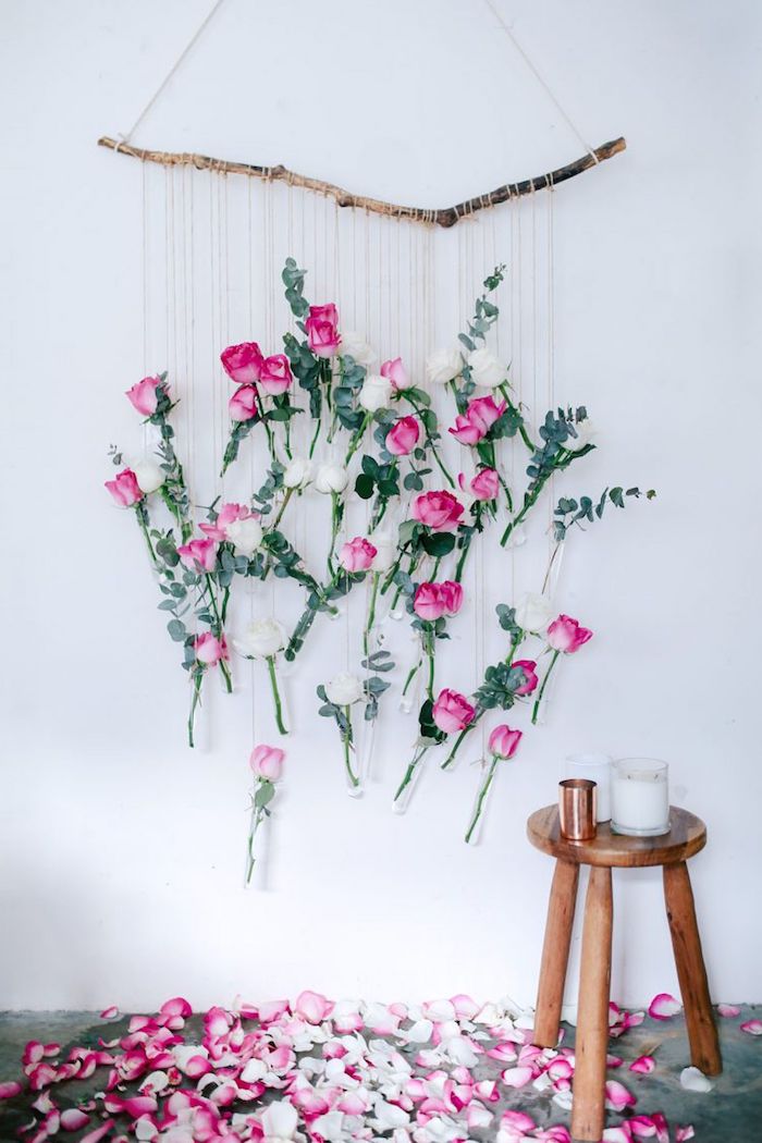 activité saint valentin des roses suspendus a cote d une bougie pose sur une tabourette en bois