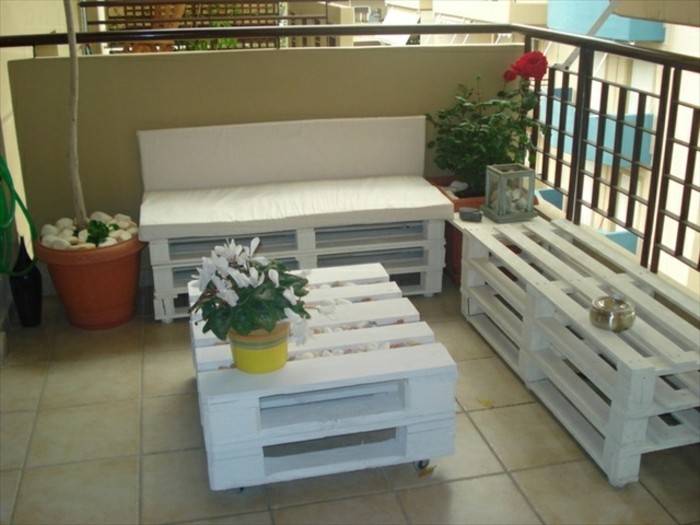 une-terrasse-amenagee-avec-des-meubles-en-palette-blancs-canape-palette-table-basse-blanche-a-roulettes