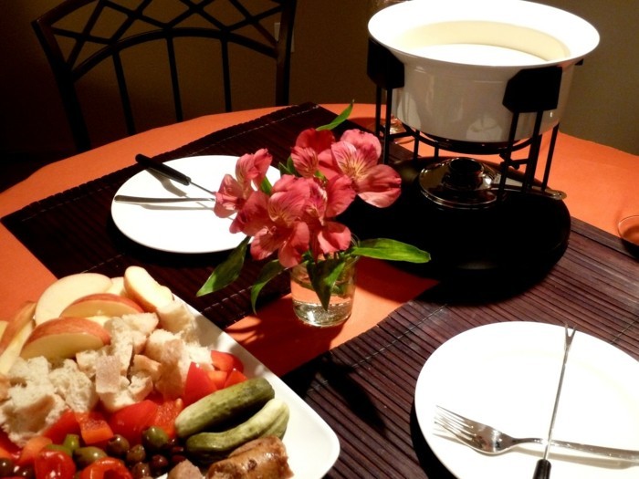 idee-repas-amoureux-repas-au-chandelle-couple-fondue-et-table-decore-avec-fleurs