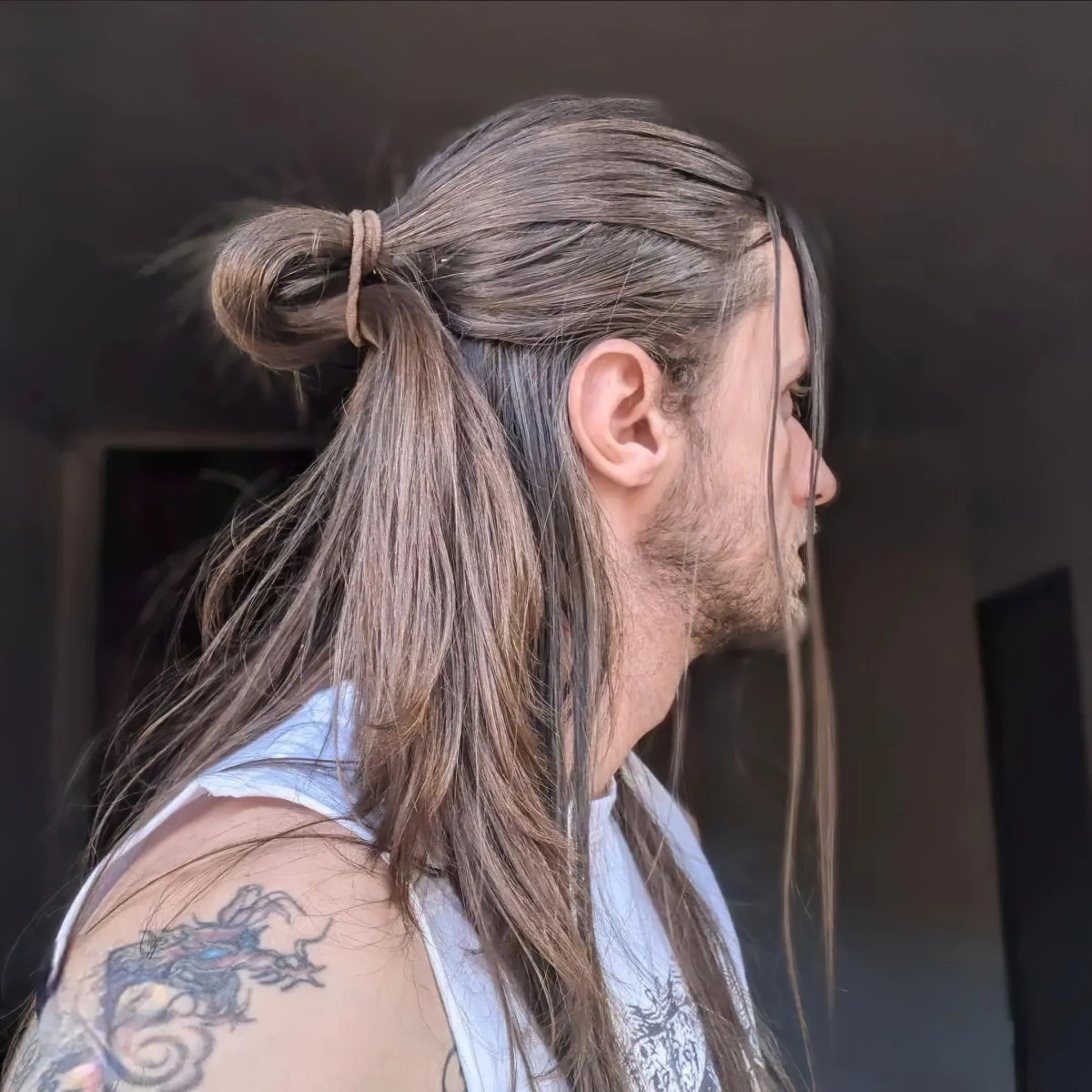 half bun chignon cheveux longs homme coiffure barbe debardeur tatouage epale