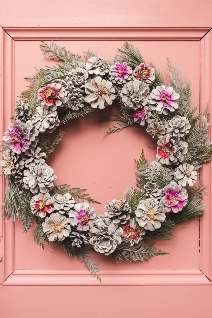 exemple comment décorer une porte d'entrée pour Noël avec objet diy, modèle de couronne de Noël fait main avec pommes de pin